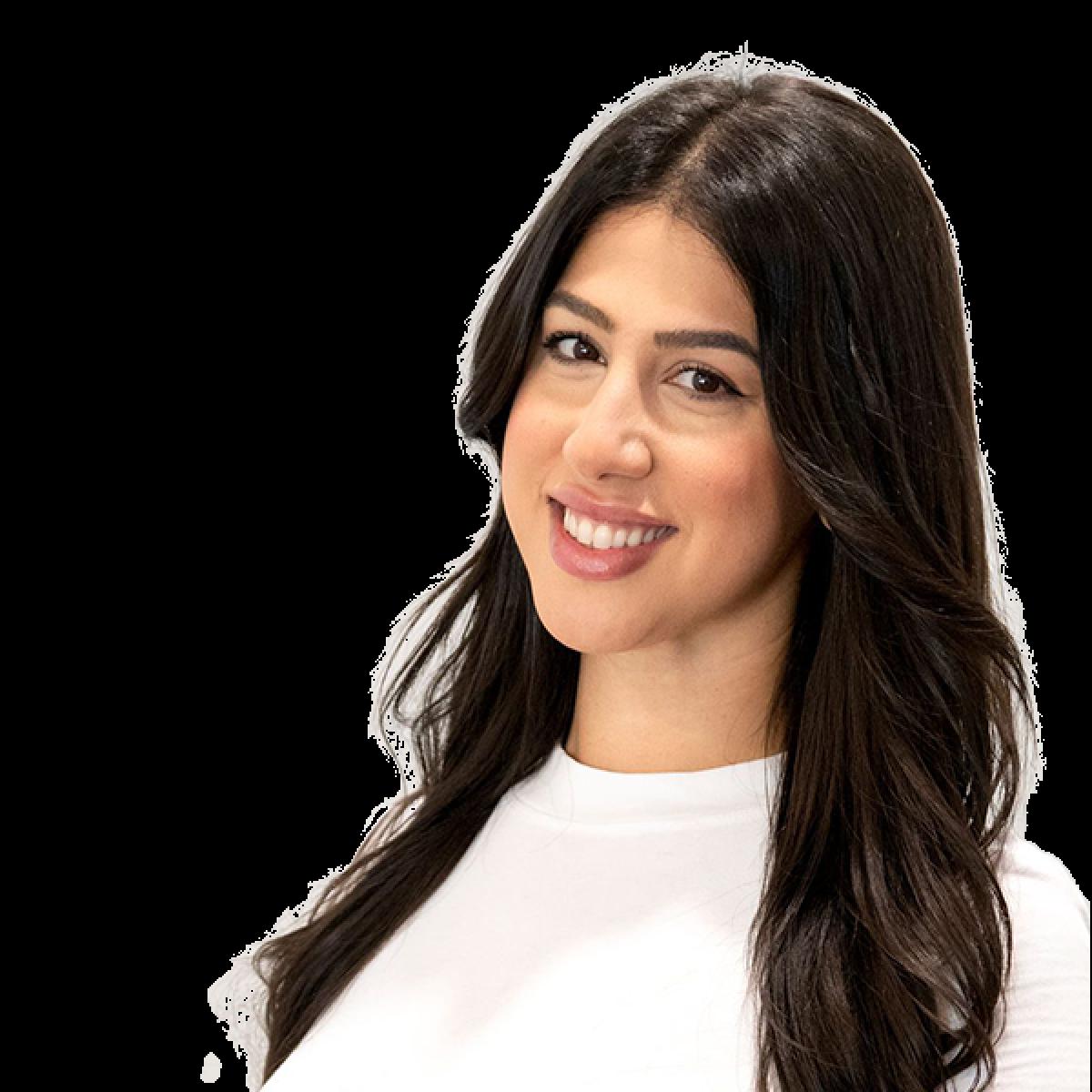 Professional headshot of a smiling female healthcare practitioner with long dark hair wearing a white top