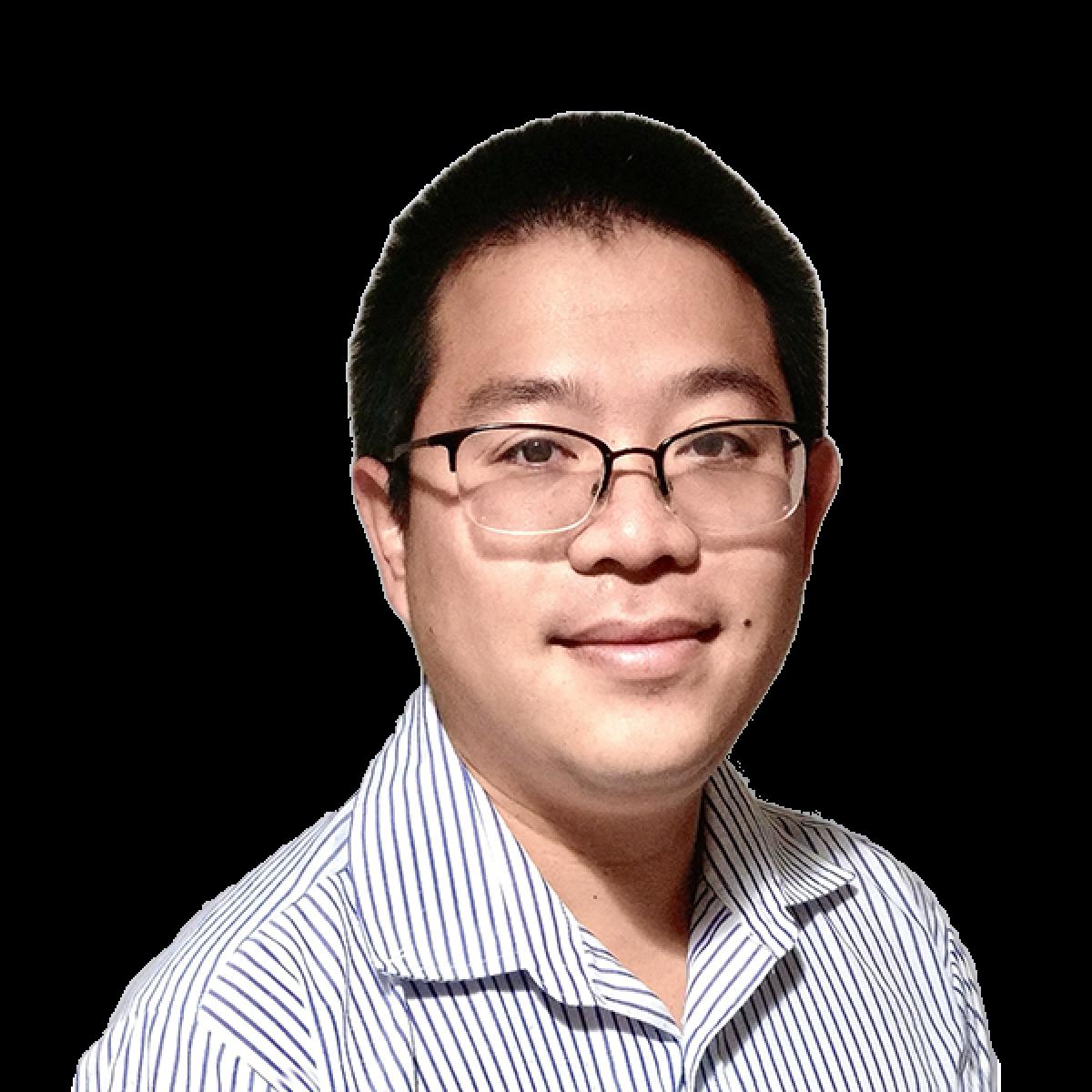 Professional headshot of male doctor wearing glasses and blue striped shirt