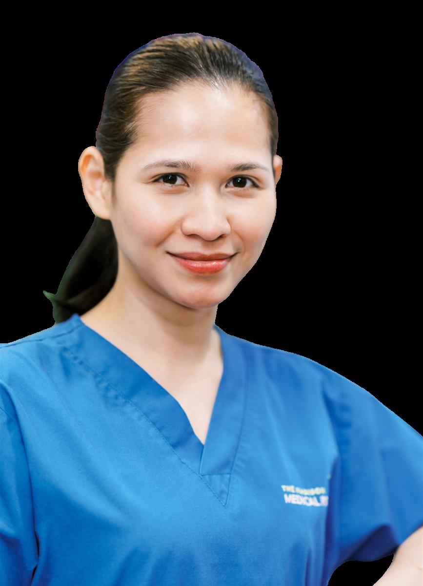 Female healthcare professional in blue medical scrubs smiling at camera